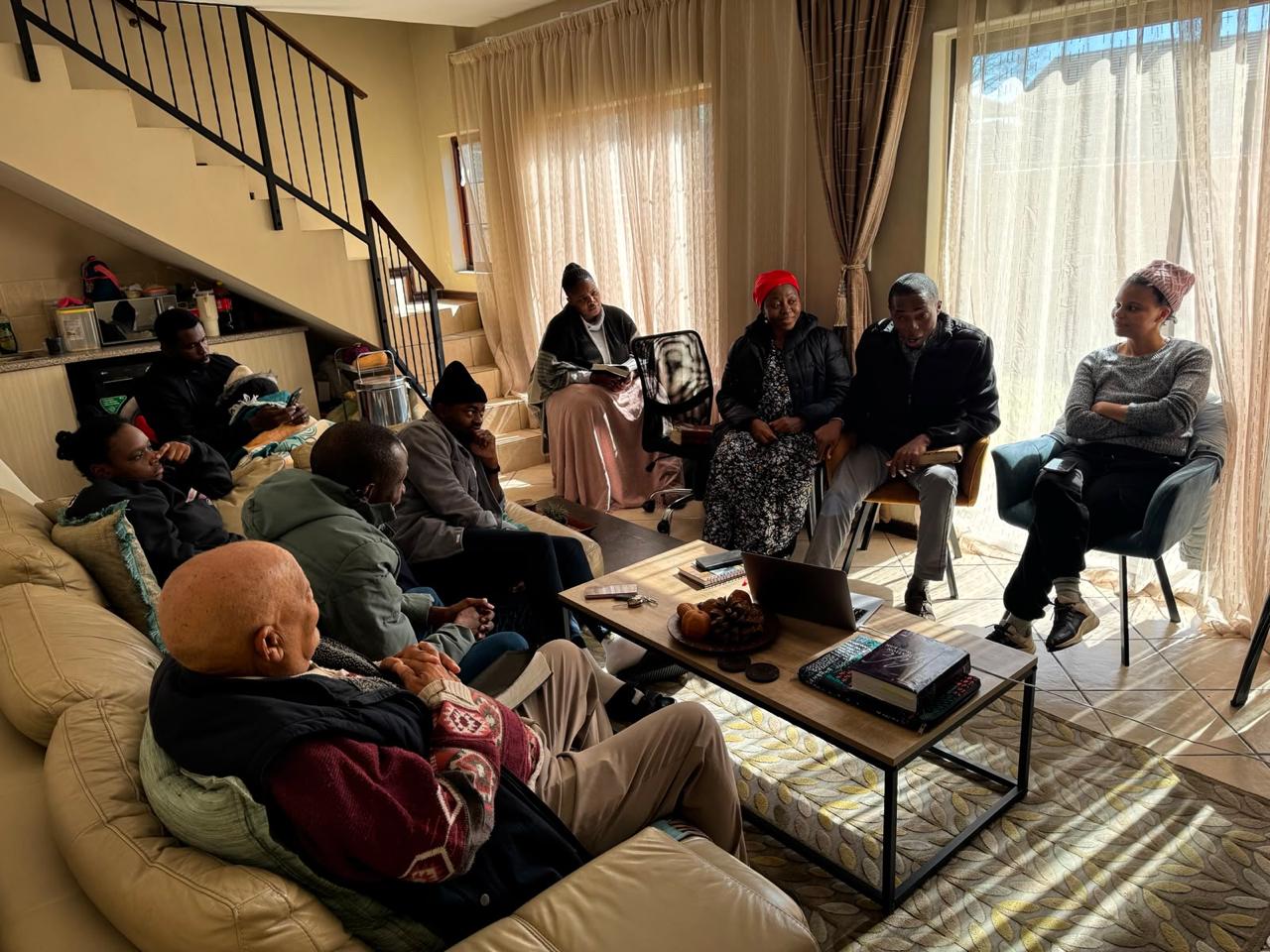 Brothers and sisters sharing the Word together in a sunlit living room